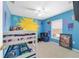 Bedroom featuring bright blue walls, bunk beds, and colorful accents, creating a vibrant space at 4624 Se 32Nd Pl, Ocala, FL 34480