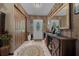 Inviting foyer featuring a decorative rug, front door with glass, and plenty of closet space at 4710 Se 30Th Ct, Ocala, FL 34480