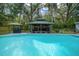 Relaxing pool area with a covered gazebo, offering shade and a perfect spot for lounging at 4710 Se 30Th Ct, Ocala, FL 34480