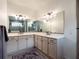 Bathroom with dual sinks, white cabinetry, modern lighting, and large mirrors at 4743 Nw 11Th Ct, Ocala, FL 34475