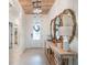 Bright foyer with tile flooring, wooden ceiling, elegant console table, and decorative mirrors at 4743 Nw 11Th Ct, Ocala, FL 34475