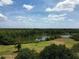 Scenic aerial view of the community showcasing a lake, lush green landscape, and clear blue sky at 606 Midway Dr # B, Ocala, FL 34472