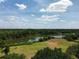 Stunning aerial view featuring the property, green landscape, and a serene lake under a partly cloudy sky at 606 Midway Dr # B, Ocala, FL 34472