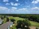 Beautiful aerial shot of the property and green golf course surrounded by trees and blue skies at 606 Midway Dr # B, Ocala, FL 34472