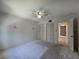 Spacious bedroom with neutral carpet, ceiling fan, closet, and access to bathroom at 606 Midway Dr # B, Ocala, FL 34472