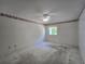 Empty bedroom with neutral carpet, ceiling fan, wallpaper border, and window at 606 Midway Dr # B, Ocala, FL 34472
