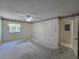 Empty bedroom with neutral carpet, ceiling fan, wallpaper border, and window at 606 Midway Dr # B, Ocala, FL 34472
