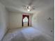 Empty bedroom with ceiling fan, neutral carpet, and window with burgundy valance at 606 Midway Dr # B, Ocala, FL 34472