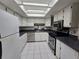 Traditional kitchen with white cabinets, tile flooring, stainless steel appliances, and skylight at 606 Midway Dr # B, Ocala, FL 34472