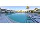 Community pool with lounge chairs, umbrellas and lake view at 606 Midway Dr # B, Ocala, FL 34472
