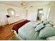 Bedroom with hardwood floors, ceiling fan, light colored dresser, and entry to bathroom or closet at 6070 Sw 98Th Loop, Ocala, FL 34476