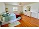 Bright bedroom with hardwood floors, ceiling fan, rocking chair, and a light colored dresser at 6070 Sw 98Th Loop, Ocala, FL 34476