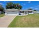 Charming home featuring a two car garage, well maintained lawn, and red shuttered windows at 6070 Sw 98Th Loop, Ocala, FL 34476