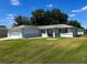 Charming single-story home with a well-maintained lawn and a two-car garage, under a blue sky at 6070 Sw 98Th Loop, Ocala, FL 34476