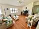 Bright living room featuring hardwood floors, cozy seating, and a ceiling fan at 6070 Sw 98Th Loop, Ocala, FL 34476