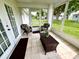 Screened in porch area with outdoor chairs, small wicker table, and view of backyard at 6070 Sw 98Th Loop, Ocala, FL 34476