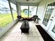 Screened in porch with outdoor chairs, a wicker table, and view of the backyard at 6070 Sw 98Th Loop, Ocala, FL 34476