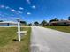 A quiet street with well-maintained homes and green lawns under a bright blue sky at 6070 Sw 98Th Loop, Ocala, FL 34476