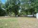 A big backyard with a fire pit, surrounded by lush green trees and privacy fence at 6306 Pecan Crse, Ocala, FL 34472