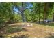 A serene backyard retreat with a cozy fire pit area, surrounded by lush trees and natural beauty at 6306 Pecan Crse, Ocala, FL 34472
