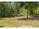 Relaxing backyard featuring mature trees surrounding a fire pit and seating area at 6306 Pecan Crse, Ocala, FL 34472