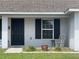 Close-up of the front door and window with dark shutters, enhancing curb appeal at 6306 Pecan Crse, Ocala, FL 34472