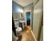 Compact bathroom featuring a shower, toilet, pedestal sink, mirror, and tiled flooring at 6498 Se 167Th Ct, Ocklawaha, FL 32179
