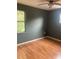 Bedroom featuring wood floors, a ceiling fan and dark colored walls and a window at 6498 Se 167Th Ct, Ocklawaha, FL 32179