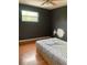 Bedroom featuring wood floors, dark walls, a window and a bed at 6498 Se 167Th Ct, Ocklawaha, FL 32179