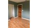 Bedroom featuring wood floors, a window and dark colored walls at 6498 Se 167Th Ct, Ocklawaha, FL 32179