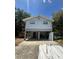 Stilt home showcasing a front entrance with a spacious carport and ladder in view at 6498 Se 167Th Ct, Ocklawaha, FL 32179