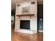 Elegant stone fireplace with a wooden mantel, decorative mirror, and hardwood floors at 6498 Se 167Th Ct, Ocklawaha, FL 32179