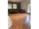 This living room features wood floors, two couches, a table and two large windows to let in natural light at 6498 Se 167Th Ct, Ocklawaha, FL 32179