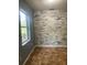 Room featuring brown tile flooring and a unique brick wall at 6498 Se 167Th Ct, Ocklawaha, FL 32179