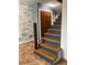 Staircase with wood treads and painted risers adjacent to a brick accent wall at 6498 Se 167Th Ct, Ocklawaha, FL 32179