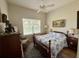 Bedroom with hardwood floors, ceiling fan, bed, and chest of drawers at 6836 Sw 112Th St, Ocala, FL 34476