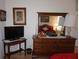 Bedroom view showing a dresser with mirror reflecting the bed and a TV at 6836 Sw 112Th St, Ocala, FL 34476