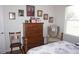 Bedroom with hardwood floors, chair, dresser, and natural light at 6836 Sw 112Th St, Ocala, FL 34476