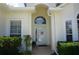 Inviting front entrance with white door, sidelights, arched window, and manicured shrubbery at 6836 Sw 112Th St, Ocala, FL 34476
