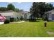 Well-manicured lawn, lush landscaping, and a vibrant American flag add charm to this home's exterior at 6836 Sw 112Th St, Ocala, FL 34476