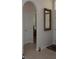 Hallway features arched doorway, tile flooring and decorative mirror at 6836 Sw 112Th St, Ocala, FL 34476