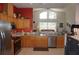 Open kitchen featuring stainless steel appliances, oak cabinets, and an adjoining living area with vaulted ceilings at 6836 Sw 112Th St, Ocala, FL 34476