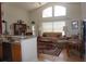 Bright living room featuring vaulted ceiling, large windows, and an open layout connected to the kitchen at 6836 Sw 112Th St, Ocala, FL 34476