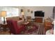 Comfortable living room with neutral sofa, patterned armchair, and a decorative area rug at 6836 Sw 112Th St, Ocala, FL 34476
