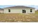 Rear exterior view of the home featuring the siding, windows, sliding glass door, and backyard at 69 Juniper Trail Loop, Ocala, FL 34480