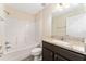 Bright bathroom features a granite countertop, framed mirror, shower-tub combination, and modern fixtures at 69 Juniper Trail Loop, Ocala, FL 34480