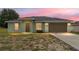 Charming single-story home with a two-car garage, grassy front yard, and a welcoming entrance at 69 Juniper Trail Loop, Ocala, FL 34480