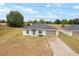 Charming single-story home with a well-manicured lawn, a two-car garage, and a paved driveway at 69 Juniper Trail Loop, Ocala, FL 34480