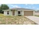 Charming single-story home with a two-car garage, grassy front yard, and a welcoming entrance at 69 Juniper Trail Loop, Ocala, FL 34480