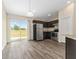 Bright kitchen features stainless steel appliances, dark cabinets, and sliding doors with a view at 69 Juniper Trail Loop, Ocala, FL 34480